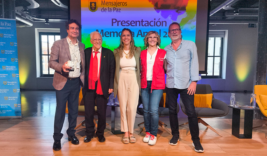 El padre Ángel, con bufanda roja, junto a los presentadores de la memoria anual de 2025.