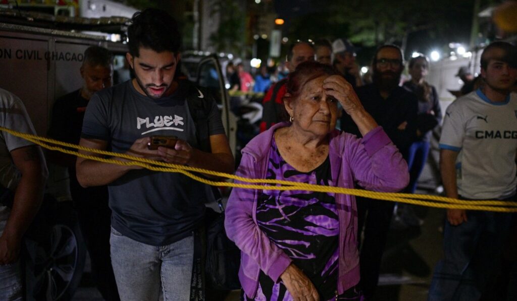 Caraqueños al lado de un edificio derrumbado. Foto: Reuters / Gaby Oraa.