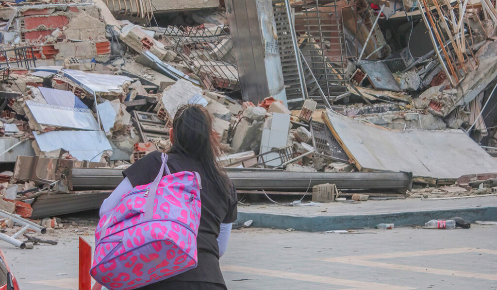 Una mujer contempla los escombros de un edificio. Los religiosos acompañan a los familiares que esperan noticias.