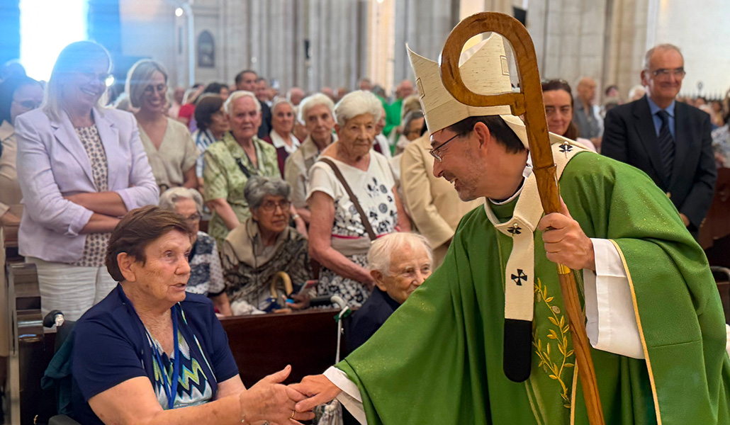 El cardenal Cobo saluda a una de las asistentes a la Misa en la Almudena.