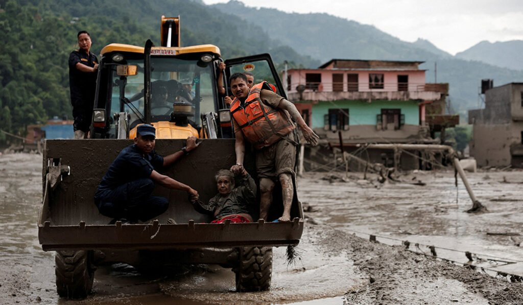 Una superviviente es trasladada a un lugar más seguro en una retroexcavadora JCB tras una crecida repentina en Trishuli, en el distrito de Nuwakot (Nepal), el 26 de agosto de 2026.