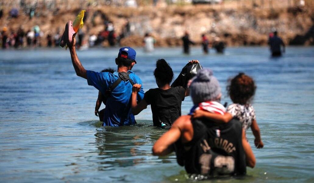 Una familia intenta cruzar con sus hijos el Río Grande. Foto: OSV News photo/Daniel Becerril, Reuters