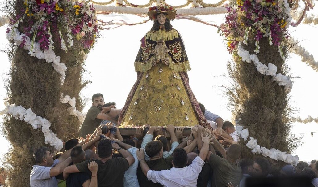 Momento en que los almonteños saltan la reja y comienza el traslado de la virgen del rocío. Foto: EFE