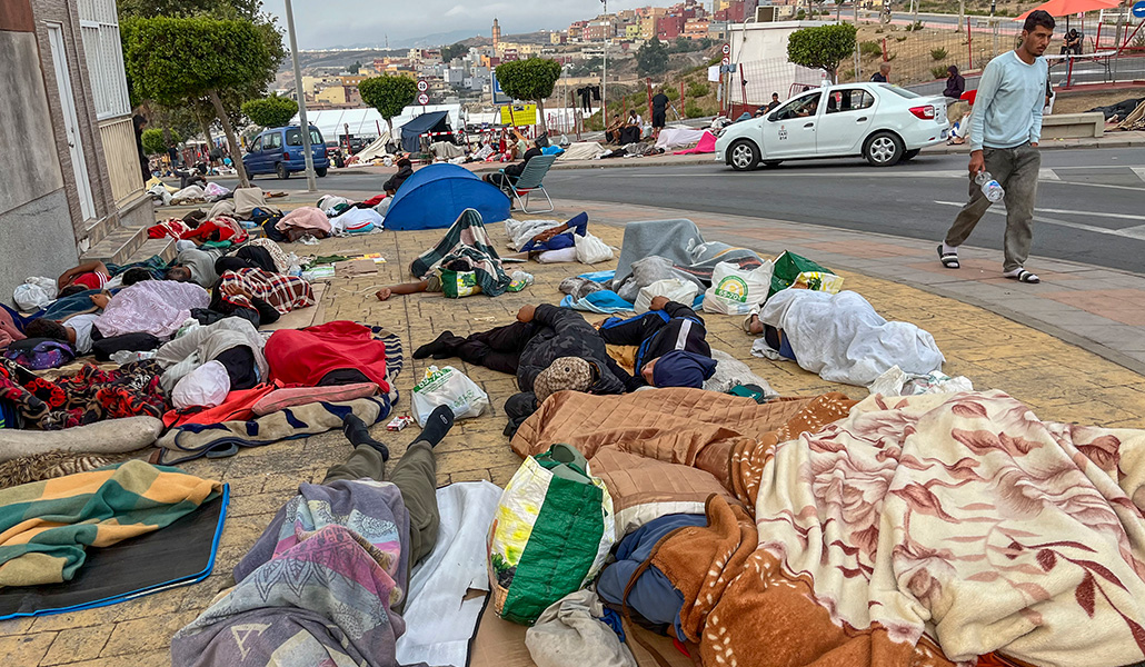 Migrantes duermen en plena calle el domingo a la espera de acceder a un campamento temporal.