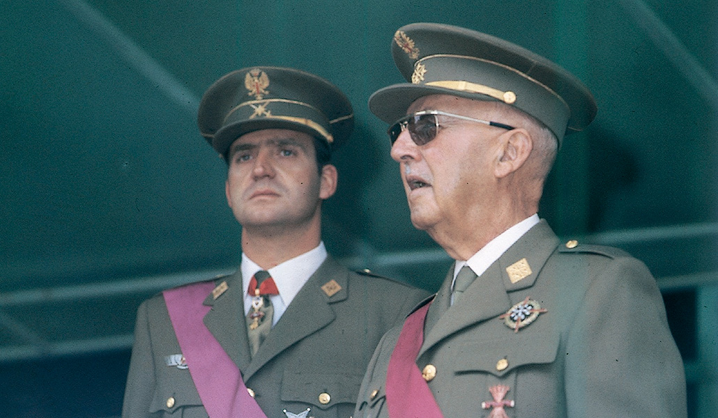 El, entonces, príncipe Juan Carlos con Francisco Franco durante un desfile del 18 de julio.