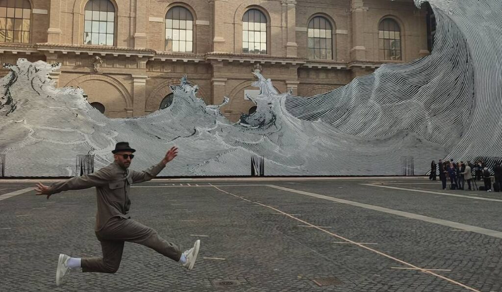 El artista JR delante de su obra. Foto: Vatican News.