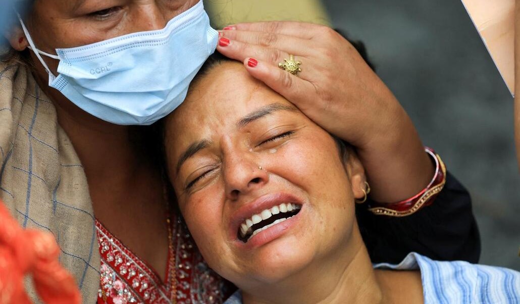 Familias enteras lloran a sus muertos a las puertas del tanatorio de Chitwan. Foto: OSV News/Adnan Abidi, Reuters