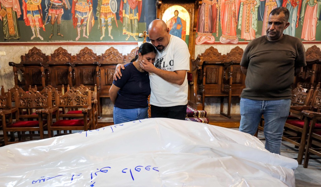 Esther, hija de Mary, llora ante el cuerpo de su madre y su abuela. Foto: AFP / Omar al Qattaa.