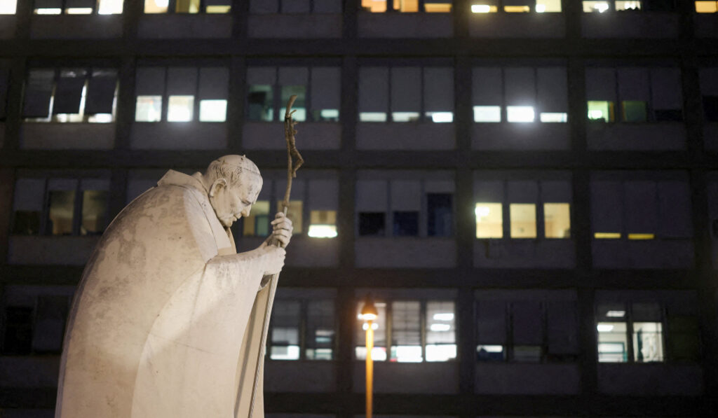 El Gemelli en la noche del martes, con la conocida escultura de san Juan Pablo II. Foto: OSV News / Reuters / Matteo Minnella.