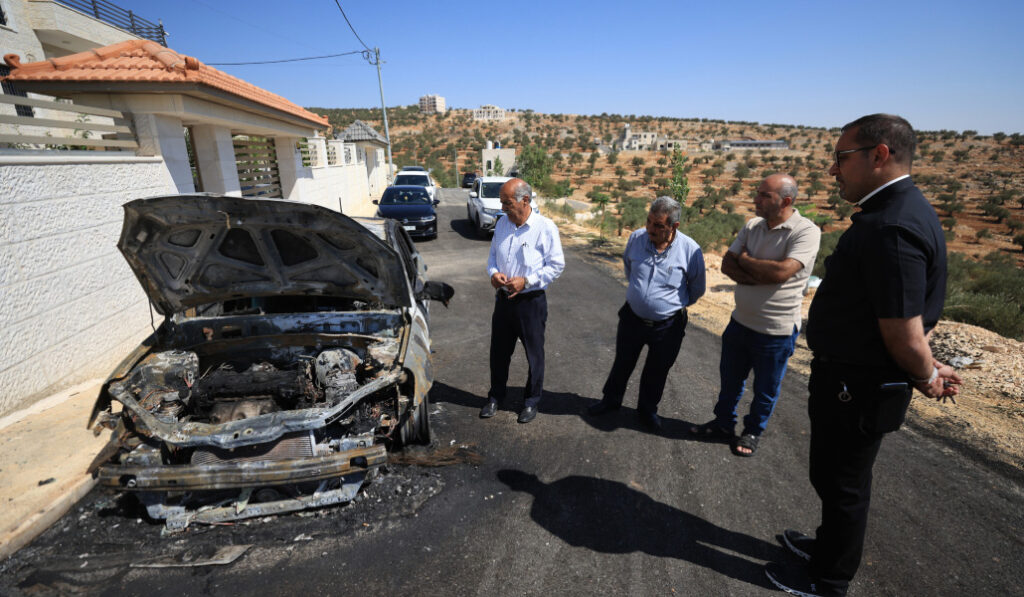 El párroco (derecha) hace balance de daños tras uno de los varios ataques sufridos en julio de 2025. Foto: EFE / EPA / Alaab Badarneh.